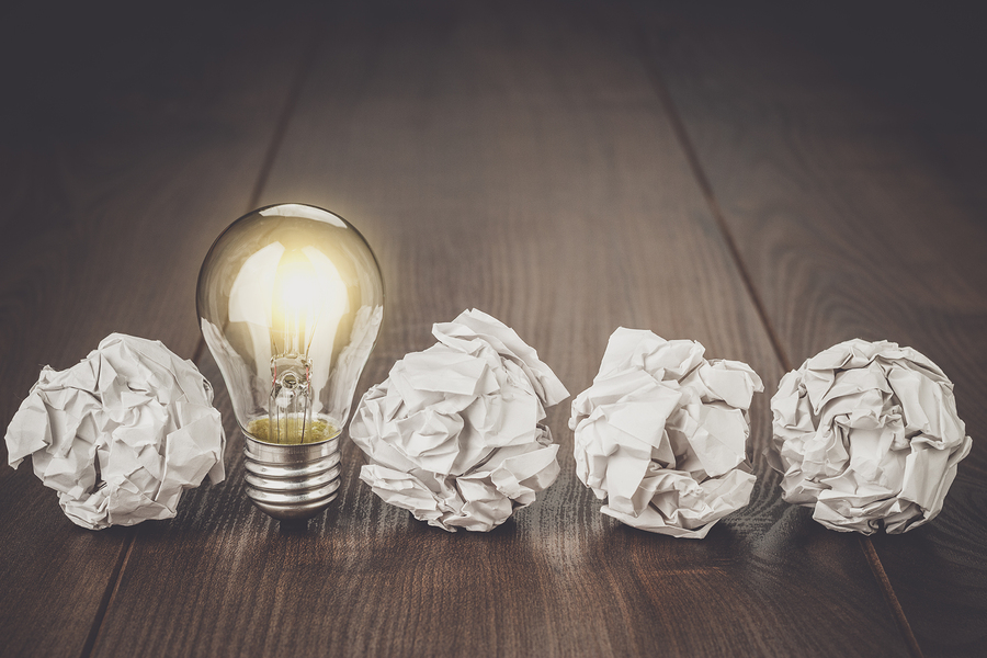 Great idea business concept. Business idea brainstorming concept with crumpled office paper. Great idea as light bulb standing on the office table. Business meeting concept. Business plan idea brainstorming concept.